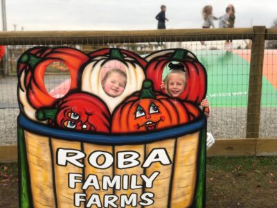 Little students posing with a Roba Family Farm sign