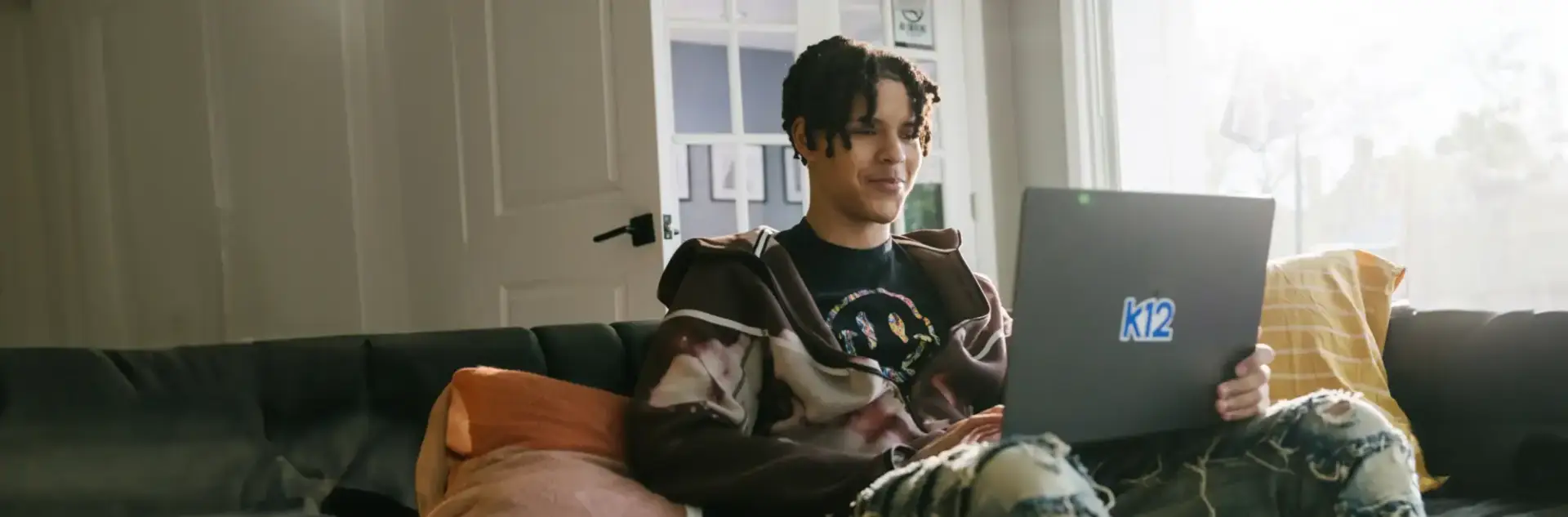 High school student using his laptop sitting on the caouch