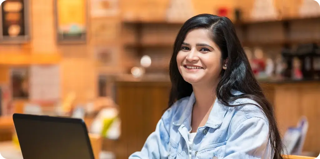 High school student wearing a ligt blue shirt working with her laptop