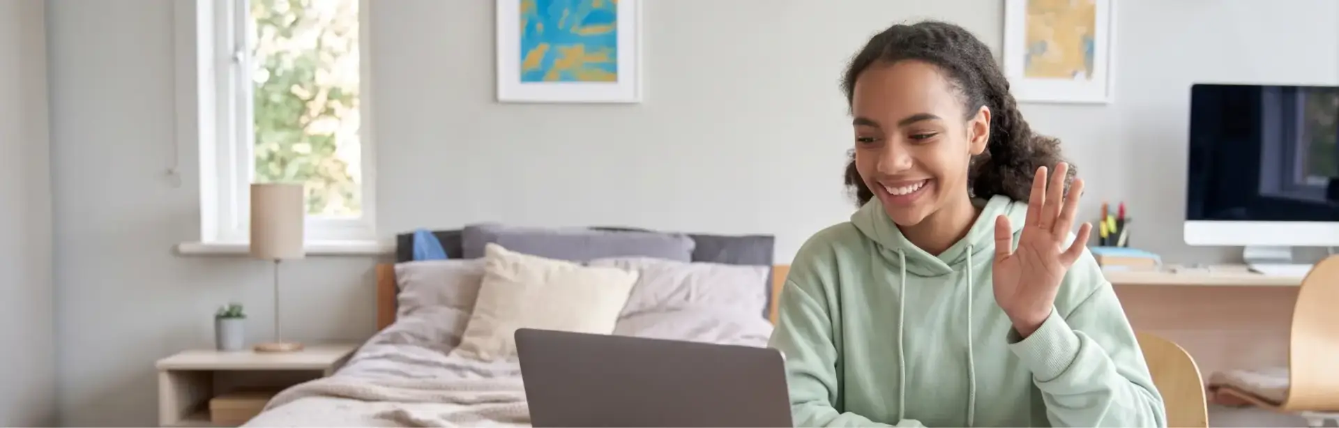 High school student attending to an online class wearing a light green hoodie