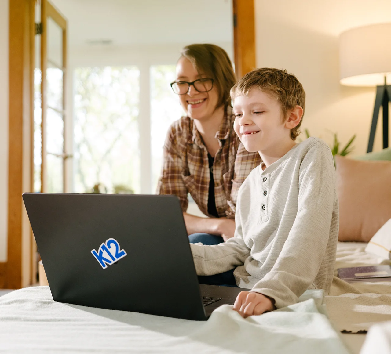 Mother and her son working together with their laptop at home