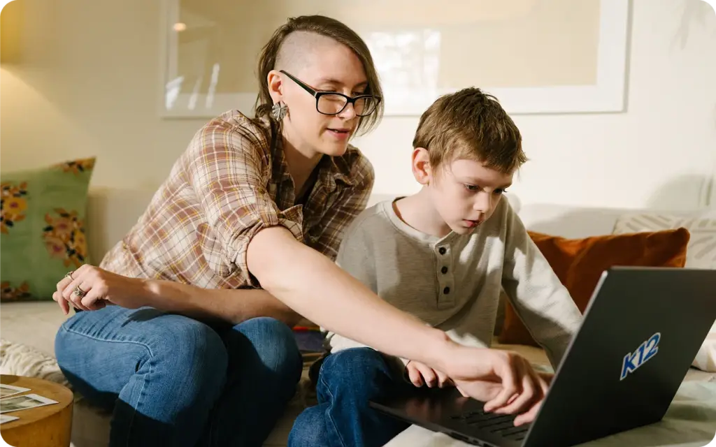 Parent and their child working together with their K12 laptop